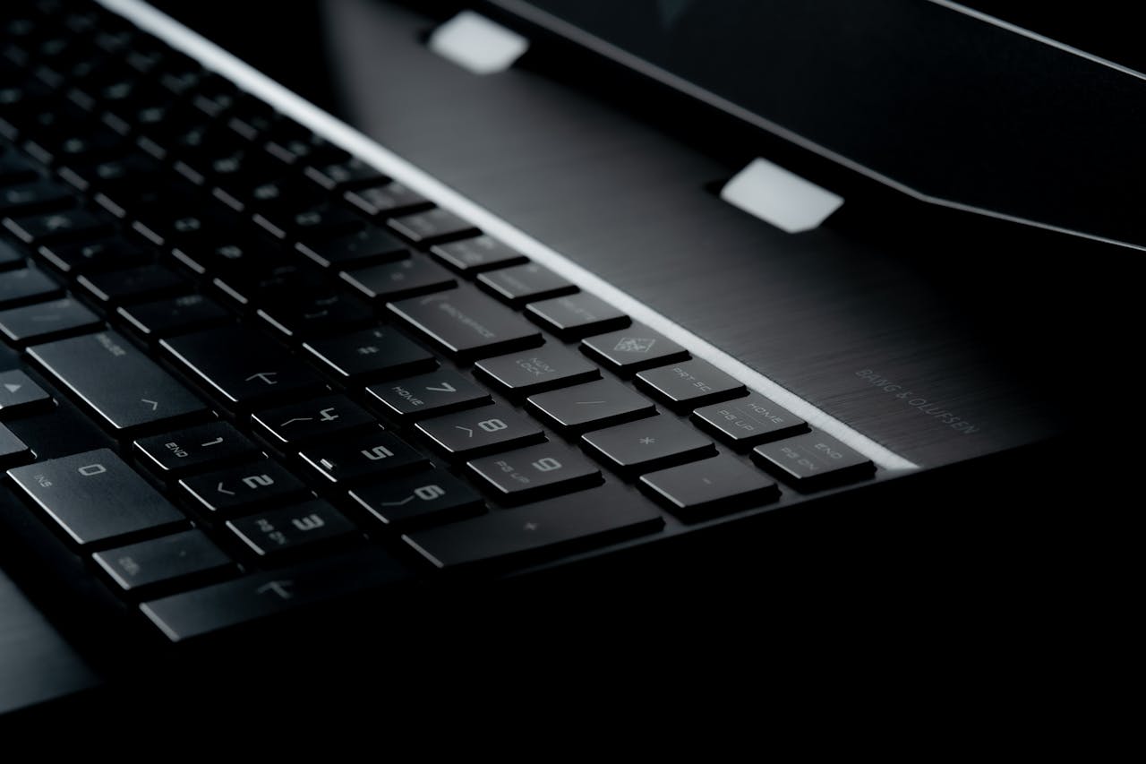 High-quality close-up image of a sleek modern laptop keyboard with illuminated keys.